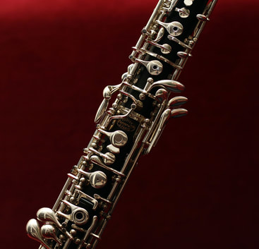 Decorative picture of an oboe against a read and black background.