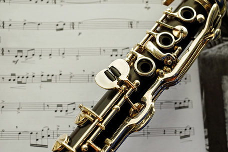 Decorative picture of a clarinet over sheet music.